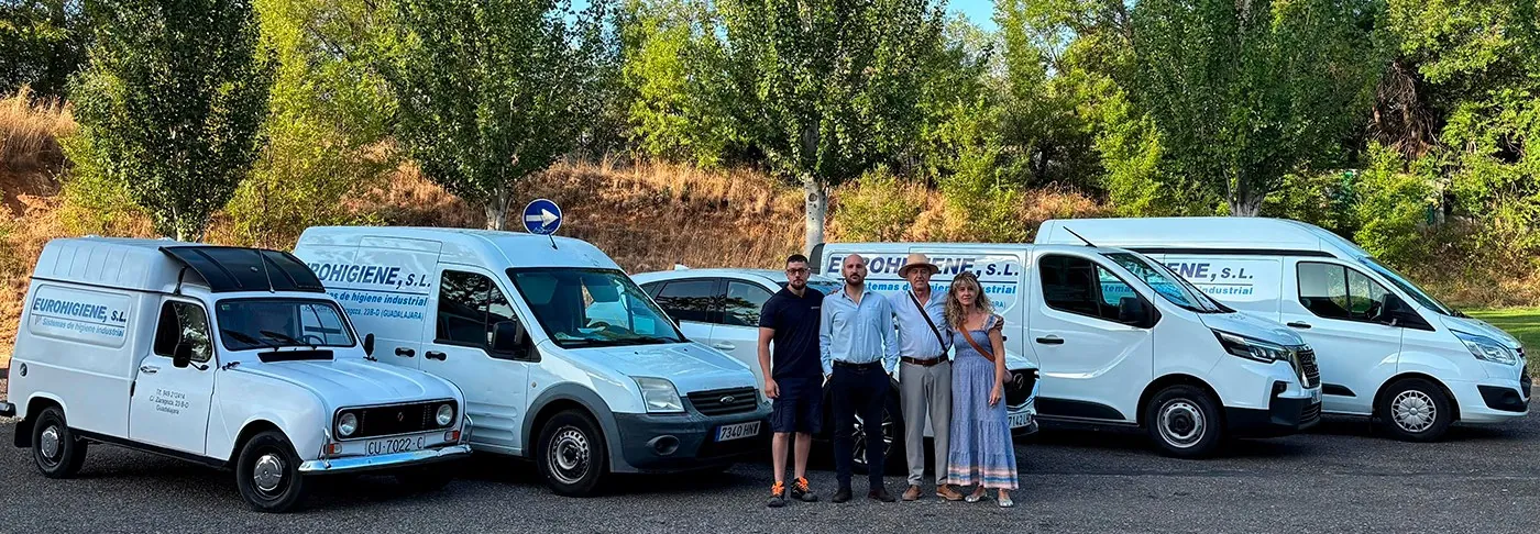 Equipo de Eurohigiene junto a sus furgonetas de reparto, desde un clásico Renault 4 hasta los vehículos actuales