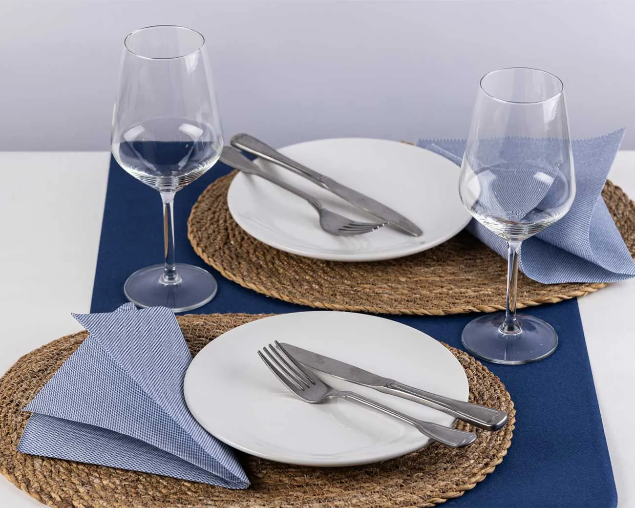 Mesa con camino azul marino, bajoplatos de fibra y servilletas celestes