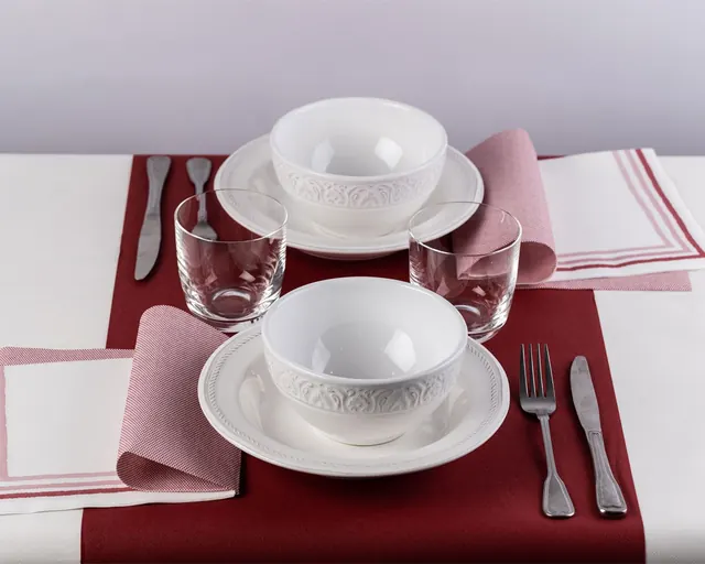 Camino burdeos con servilletas rosas y vajilla blanca