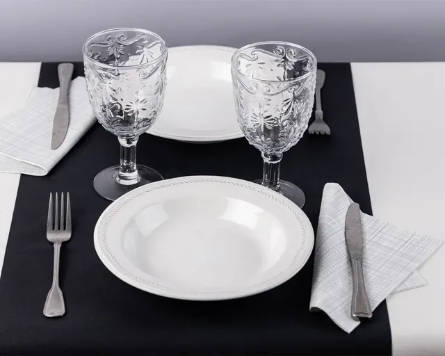 Mantel negro con servilleta gris y copas talladas