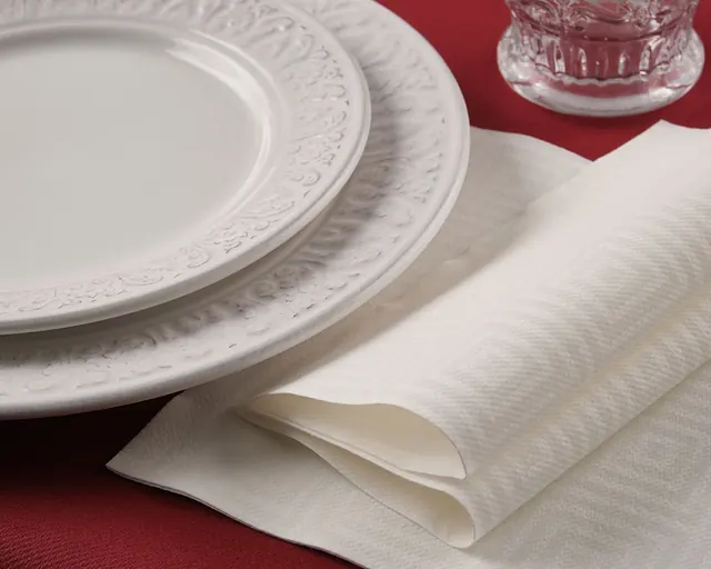 Servilleta blanca con relieve sobre mantel rojo