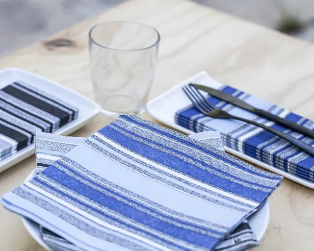 Servilletas de rayas azules sobre mesa de madera clara